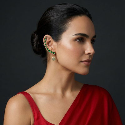 The Emerald Arc Ear Cuff with vivid emerald stones and bold sculptural gold design by Ozel