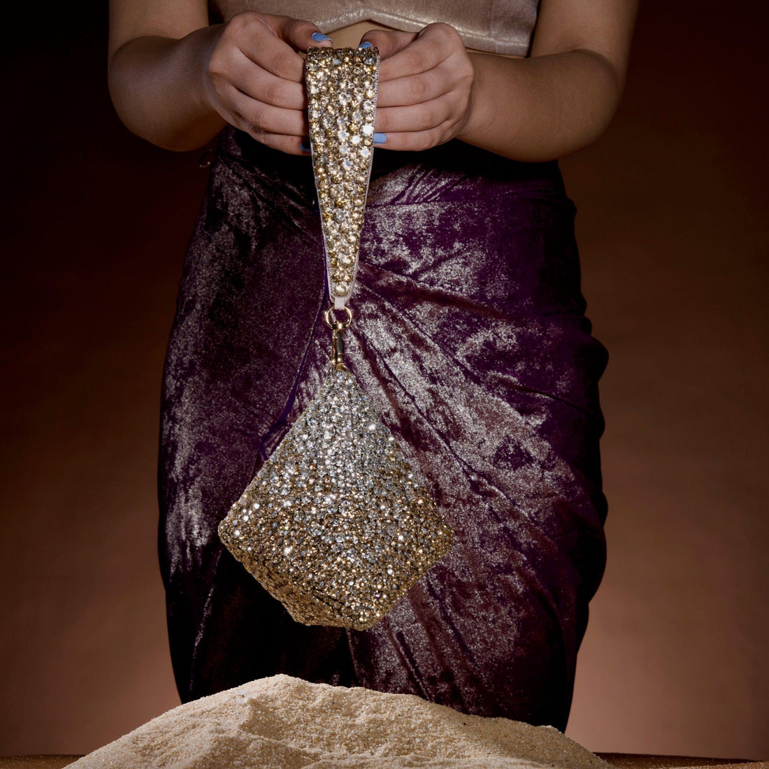 Pyramid rhinestone clutch held by model — Ozel